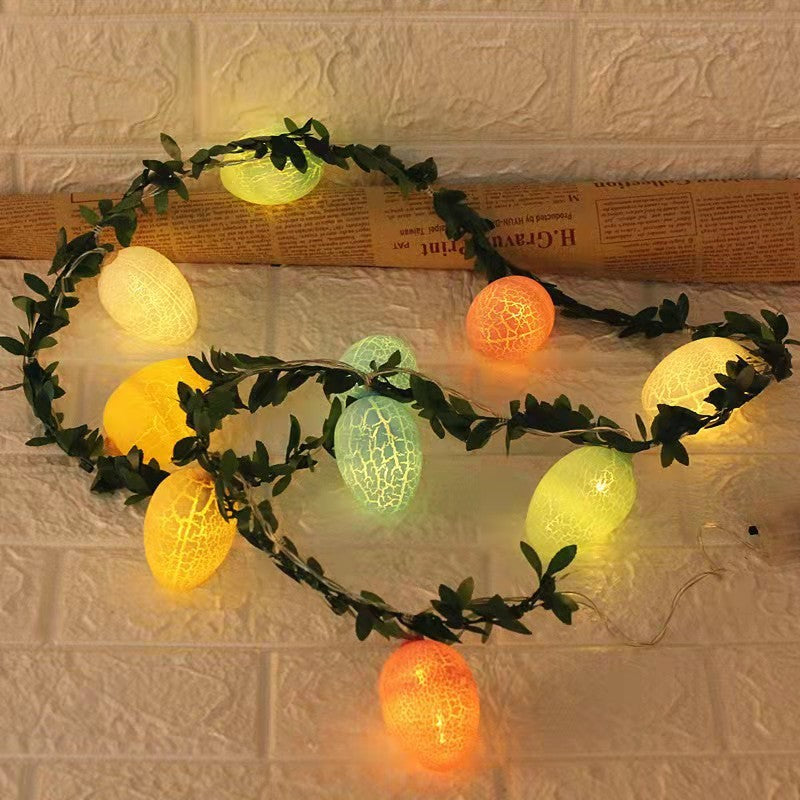 Easter egg-shaped string lights with warm glowing colors, wrapped in green leaf rattan, creating a cozy and festive ambiance for home decor.


